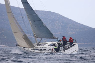 Bodrum, Hindi. 16 Nisan 2023: Yelkenliler Ege Denizi 'nin mavi sularında, ünlü tatil beldesi Bodrum' un kıyılarında rüzgarlı havada yelken açıyor..