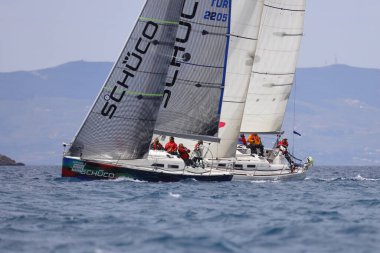 Bodrum, Hindi. 16 Nisan 2023: Yelkenliler Ege Denizi 'nin mavi sularında, ünlü tatil beldesi Bodrum' un kıyılarında rüzgarlı havada yelken açıyor..