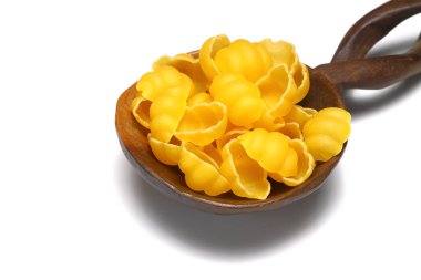 Beyaz arka planda tahta kaşıkta çiğ makarna gnocchetti. İtalyan mutfak malzemelerinin üst görünümü.