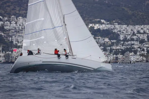 Bodrum, Hindi. 16 Nisan 2023: Yelkenliler Ege Denizi 'nin mavi sularında, ünlü tatil beldesi Bodrum' un kıyılarında rüzgarlı havada yelken açıyor..