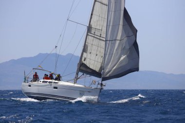 Bodrum, Hindi. 16 Nisan 2023: Yelkenliler Ege Denizi 'nin mavi sularında, ünlü tatil beldesi Bodrum' un kıyılarında rüzgarlı havada yelken açıyor..