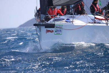 Bodrum, Hindi. 16 Nisan 2023: Yelkenliler Ege Denizi 'nin mavi sularında, ünlü tatil beldesi Bodrum' un kıyılarında rüzgarlı havada yelken açıyor..