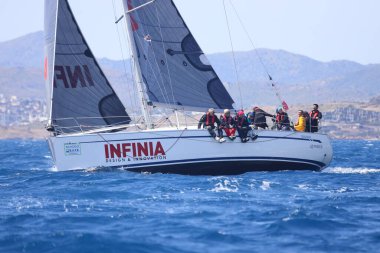 Bodrum, Hindi. 16 Nisan 2023: Yelkenliler Ege Denizi 'nin mavi sularında, ünlü tatil beldesi Bodrum' un kıyılarında rüzgarlı havada yelken açıyor..