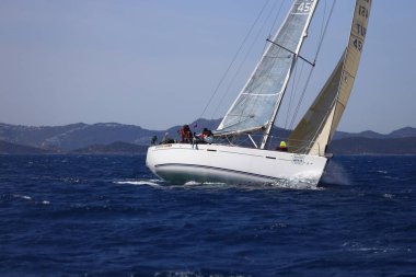 Bodrum, Hindi. 16 Nisan 2023: Yelkenliler Ege Denizi 'nin mavi sularında, ünlü tatil beldesi Bodrum' un kıyılarında rüzgarlı havada yelken açıyor..