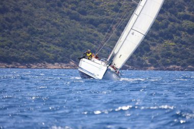 Bodrum, Hindi. 16 Nisan 2023: Yelkenliler Ege Denizi 'nin mavi sularında, ünlü tatil beldesi Bodrum' un kıyılarında rüzgarlı havada yelken açıyor..
