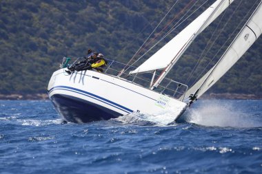 Bodrum, Hindi. 16 Nisan 2023: Yelkenliler Ege Denizi 'nin mavi sularında, ünlü tatil beldesi Bodrum' un kıyılarında rüzgarlı havada yelken açıyor..
