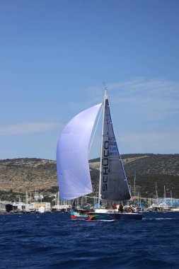 Bodrum, Hindi. 16 Nisan 2023: Yelkenliler Ege Denizi 'nin mavi sularında, ünlü tatil beldesi Bodrum' un kıyılarında rüzgarlı havada yelken açıyor..