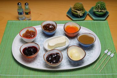 Türk kahvaltı masası. Hamur işleri, sebzeler, yeşiller, zeytinler, peynirler, kızarmış yumurtalar, reçeller, bal, bakır demlikte çay ve lale bardakları, geniş kompozisyon