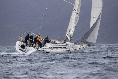 Bodrum, Hindi. 02 Nisan 2023: Ege Denizi 'nin mavi sularında, ünlü tatil beldesi Bodrum' un kıyılarında yelkenliler rüzgarlı havada yelken açıyor.