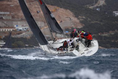 Bodrum, Hindi. 02 Nisan 2023: Ege Denizi 'nin mavi sularında, ünlü tatil beldesi Bodrum' un kıyılarında yelkenliler rüzgarlı havada yelken açıyor.
