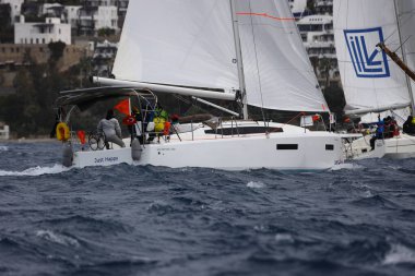 Bodrum, Hindi. 02 Nisan 2023: Ege Denizi 'nin mavi sularında, ünlü tatil beldesi Bodrum' un kıyılarında yelkenliler rüzgarlı havada yelken açıyor.