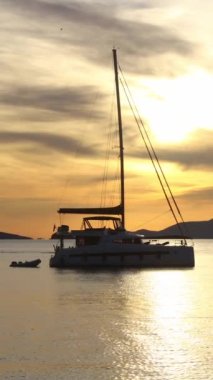 Günbatımında yalnız yelkenli. Atmosferik deniz manzarası. Sosyal medya için dikey video.