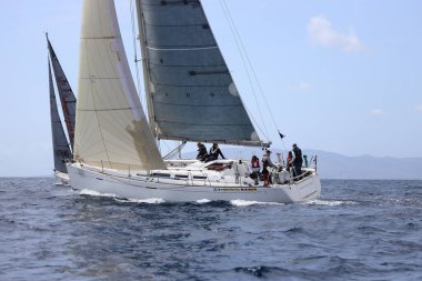 Bodrum, Hindi. 01 Nisan 2023: Ege Denizi 'nin mavi sularında, ünlü tatil beldesi Bodrum' un kıyılarında, rüzgarlı havada yelkenliler yelken açıyor.