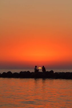 Bodrum, Mugla, Türkiye. 3 Temmuz 2020: Ünlü tatil beldesi Bodrum 'da turistler gün batımında balık tutarak vakit geçirir.