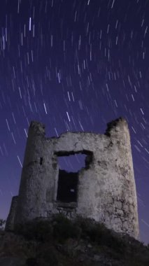 Gece gökyüzündeki yel değirmenini mahveder. Yıldız izleri zaman ayarlı. Sosyal medya için dikey video