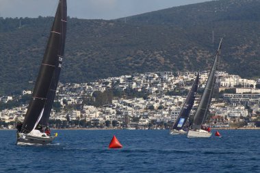 Bodrum, Hindi. 09 Şubat 2019: Yelkenliler Ege Denizi 'nin mavi sularında, ünlü tatil beldesi Bodrum' un kıyılarında rüzgarlı havada yelken açıyorlar..