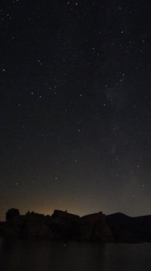 Önünde bir dağ tepesi olan Samanyolu 'nun yıldızlarının görüntüsü. Gece gökyüzü doğa yaz manzarası. Perseid Meteor yağmuru gözlemi. Sosyal medya için dikey video.