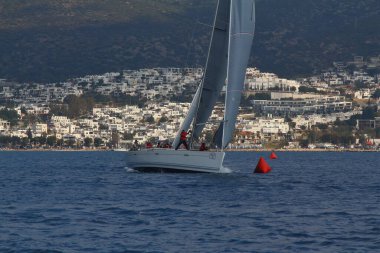 Bodrum, Hindi. 09 Şubat 2019: Yelkenliler Ege Denizi 'nin mavi sularında, ünlü tatil beldesi Bodrum' un kıyılarında rüzgarlı havada yelken açıyorlar..