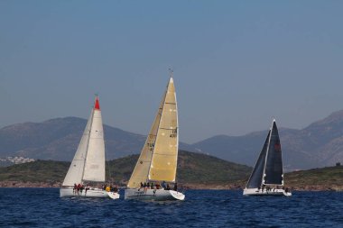 Bodrum, Hindi. 23 Mart 2019: Yelkenliler Ege Denizi 'nin mavi sularında, ünlü tatil beldesi Bodrum' un kıyılarında rüzgarlı havada yelken açıyorlar..