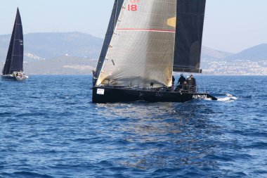Bodrum, Hindi. 23 Mart 2019: Yelkenliler Ege Denizi 'nin mavi sularında, ünlü tatil beldesi Bodrum' un kıyılarında rüzgarlı havada yelken açıyorlar..