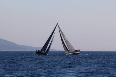 Bodrum, Hindi. 23 Mart 2019: Yelkenliler Ege Denizi 'nin mavi sularında, ünlü tatil beldesi Bodrum' un kıyılarında rüzgarlı havada yelken açıyorlar..