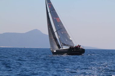 Bodrum, Hindi. 23 Mart 2019: Yelkenliler Ege Denizi 'nin mavi sularında, ünlü tatil beldesi Bodrum' un kıyılarında rüzgarlı havada yelken açıyorlar..