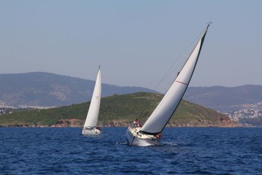Bodrum, Hindi. 23 Mart 2019: Yelkenliler Ege Denizi 'nin mavi sularında, ünlü tatil beldesi Bodrum' un kıyılarında rüzgarlı havada yelken açıyorlar..