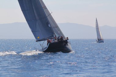 Bodrum, Hindi. 23 Mart 2019: Yelkenliler Ege Denizi 'nin mavi sularında, ünlü tatil beldesi Bodrum' un kıyılarında rüzgarlı havada yelken açıyorlar..