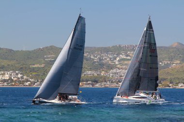 Bodrum, Hindi. 23 Mart 2019: Yelkenliler Ege Denizi 'nin mavi sularında, ünlü tatil beldesi Bodrum' un kıyılarında rüzgarlı havada yelken açıyorlar..