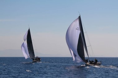Bodrum, Hindi. 23 Mart 2019: Yelkenliler Ege Denizi 'nin mavi sularında, ünlü tatil beldesi Bodrum' un kıyılarında rüzgarlı havada yelken açıyorlar..