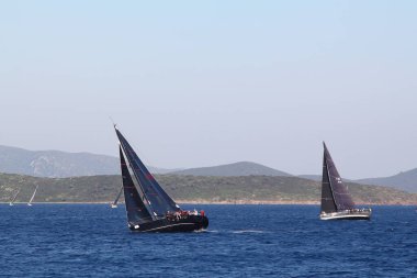 Bodrum, Hindi. 23 Mart 2019: Yelkenliler Ege Denizi 'nin mavi sularında, ünlü tatil beldesi Bodrum' un kıyılarında rüzgarlı havada yelken açıyorlar..