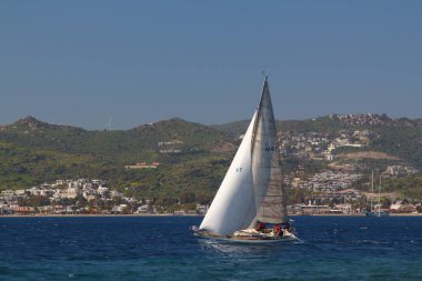 Bodrum, Hindi. 23 Mart 2019: Yelkenliler Ege Denizi 'nin mavi sularında, ünlü tatil beldesi Bodrum' un kıyılarında rüzgarlı havada yelken açıyorlar..