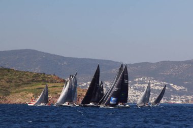 Bodrum, Hindi. 23 Mart 2019: Yelkenliler Ege Denizi 'nin mavi sularında, ünlü tatil beldesi Bodrum' un kıyılarında rüzgarlı havada yelken açıyorlar..