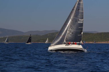 Bodrum, Hindi. 23 Mart 2019: Yelkenliler Ege Denizi 'nin mavi sularında, ünlü tatil beldesi Bodrum' un kıyılarında rüzgarlı havada yelken açıyorlar..