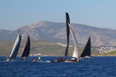 Bodrum, Hindi. 23 Mart 2019: Yelkenliler Ege Denizi 'nin mavi sularında, ünlü tatil beldesi Bodrum' un kıyılarında rüzgarlı havada yelken açıyorlar..