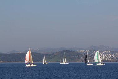 Bodrum, Hindi. 18 Ocak 2020: Yelkenliler Ege Denizi 'nin mavi sularında, ünlü tatil beldesi Bodrum' un kıyılarında rüzgarlı havada yelken açıyor..