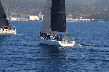 Bodrum, Hindi. 18 Ocak 2020: Yelkenliler Ege Denizi 'nin mavi sularında, ünlü tatil beldesi Bodrum' un kıyılarında rüzgarlı havada yelken açıyor..