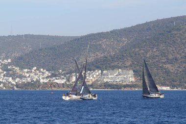 Bodrum, Hindi. 18 Ocak 2020: Yelkenliler Ege Denizi 'nin mavi sularında, ünlü tatil beldesi Bodrum' un kıyılarında rüzgarlı havada yelken açıyor..
