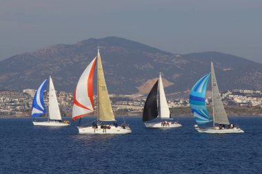 Bodrum, Hindi. 18 Ocak 2020: Yelkenliler Ege Denizi 'nin mavi sularında, ünlü tatil beldesi Bodrum' un kıyılarında rüzgarlı havada yelken açıyor..