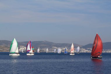 Bodrum, Hindi. 18 Ocak 2020: Yelkenliler Ege Denizi 'nin mavi sularında, ünlü tatil beldesi Bodrum' un kıyılarında rüzgarlı havada yelken açıyor..