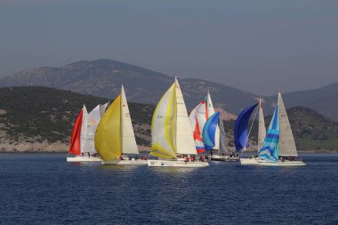 Bodrum, Hindi. 18 Ocak 2020: Yelkenliler Ege Denizi 'nin mavi sularında, ünlü tatil beldesi Bodrum' un kıyılarında rüzgarlı havada yelken açıyor..