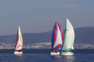 Bodrum, Hindi. 18 Ocak 2020: Yelkenliler Ege Denizi 'nin mavi sularında, ünlü tatil beldesi Bodrum' un kıyılarında rüzgarlı havada yelken açıyor..