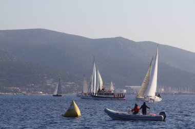 Bodrum, Hindi. 18 Ocak 2020: Yelkenliler Ege Denizi 'nin mavi sularında, ünlü tatil beldesi Bodrum' un kıyılarında rüzgarlı havada yelken açıyor..