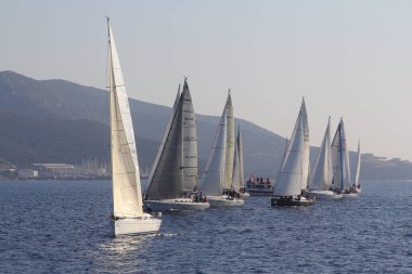 Bodrum, Hindi. 18 Ocak 2020: Yelkenliler Ege Denizi 'nin mavi sularında, ünlü tatil beldesi Bodrum' un kıyılarında rüzgarlı havada yelken açıyor..
