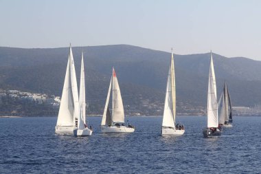 Bodrum, Hindi. 18 Ocak 2020: Yelkenliler Ege Denizi 'nin mavi sularında, ünlü tatil beldesi Bodrum' un kıyılarında rüzgarlı havada yelken açıyor..