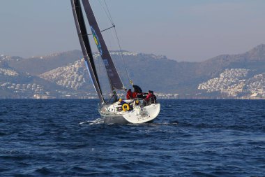 Bodrum, Hindi. 18 Ocak 2020: Yelkenliler Ege Denizi 'nin mavi sularında, ünlü tatil beldesi Bodrum' un kıyılarında rüzgarlı havada yelken açıyor..