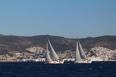 Bodrum, Hindi. 09 Şubat 2020: Ege Denizi 'nin mavi sularında, ünlü tatil beldesi Bodrum' un kıyılarında yelkenliler rüzgarlı havada yelken açıyor.