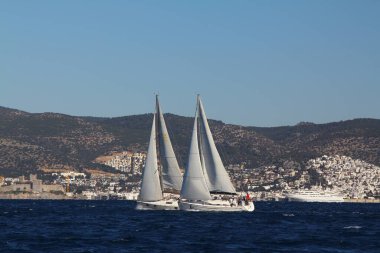Bodrum, Hindi. 09 Şubat 2020: Ege Denizi 'nin mavi sularında, ünlü tatil beldesi Bodrum' un kıyılarında yelkenliler rüzgarlı havada yelken açıyor.