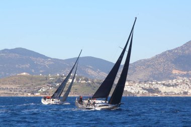 Bodrum, Hindi. 09 Şubat 2020: Ege Denizi 'nin mavi sularında, ünlü tatil beldesi Bodrum' un kıyılarında yelkenliler rüzgarlı havada yelken açıyor.
