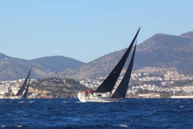 Bodrum, Hindi. 09 Şubat 2020: Ege Denizi 'nin mavi sularında, ünlü tatil beldesi Bodrum' un kıyılarında yelkenliler rüzgarlı havada yelken açıyor.